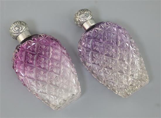 A pair of late Victorian silver lidded amethyst tinted cut glass scent flasks, 13.5cm.